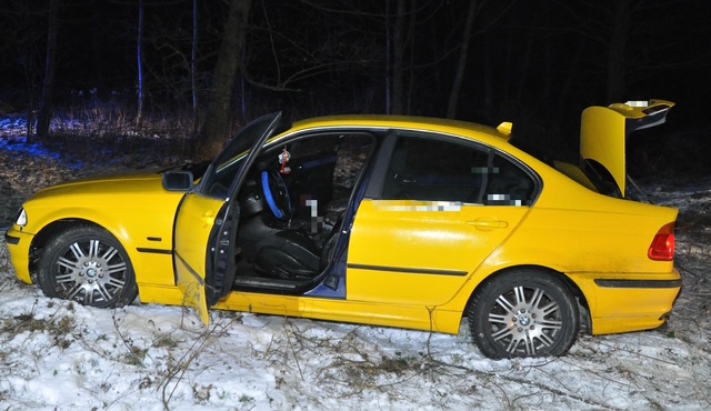 Żółte BMW porzucone w polu.