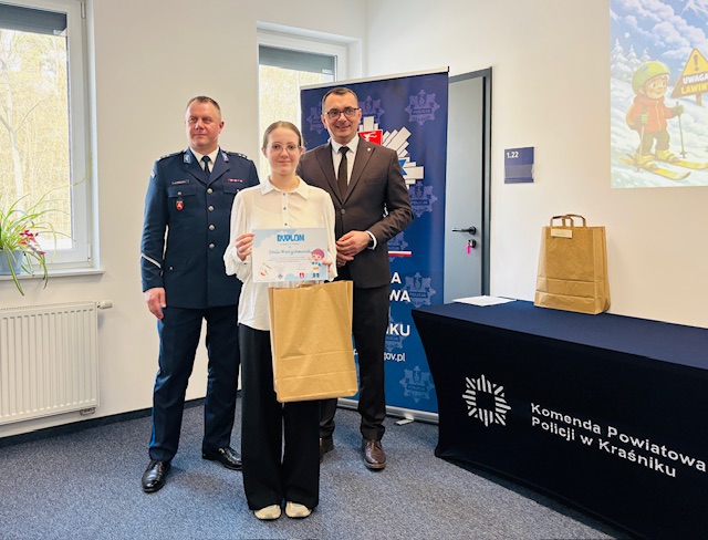 laureatka drugiego miejsca stoi z dyplomem pośrodku między Komendantem Powiatowym Policji a Zastępcą Starosty Kraśnickiego