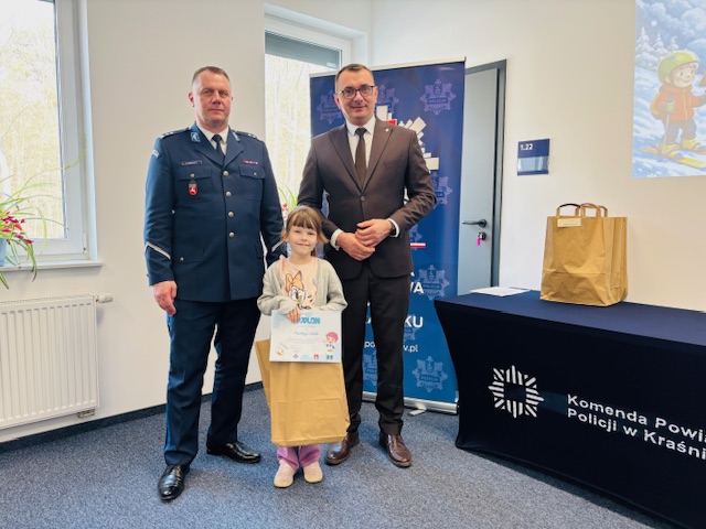laureatka trzeciego miejsca stoi z dyplomem pośrodku między Komendantem Powiatowym Policji a Zastępcą Starosty Kraśnickiego