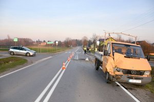 uszkodzony samochód dostawczy na poboczu drogi, policjanci wykonujący oględziny miejsca wypadku