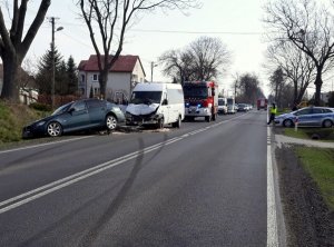 Zdjęcie przedstawia uszkodzone samochody na ulicy oraz służby mundurowe takie jak straż pożarna oraz policja.