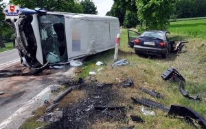 Zdjęcie przedstawia zdarzenie drogowe z udziałem białego busa oraz samochodu osobowego.