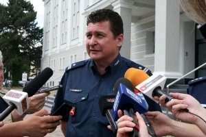 Zdjęcie przedstawia policjanta udzielającego wywiadu reporterom.