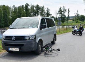 Zdjęcie przedstawia samochód, rower oraz policyjny motocykl.