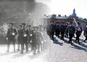 Zdjęcie przedstawia zdjęcie maszerujących policjantów różnych epok. Jedno stare zdjęcie czarno-białe po lewej stronie przecinające się z nowym w kolorze.