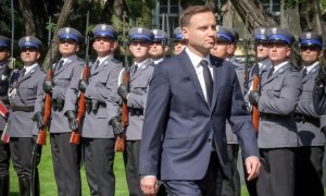 Zdjęcie przedstawia funkcjonariuszy Policji z bronią w rękach oraz Prezydenta Rzeczpospolitej Polskiej Andrzeja Dudę.