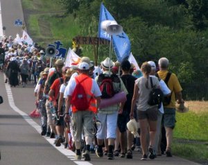 Zdjęcie przedstawia pielgrzymów idących po drodze.