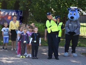 Zdjęcie przedstawia policjantów i dzieci z Inspektorkiem Kraśniczkiem.