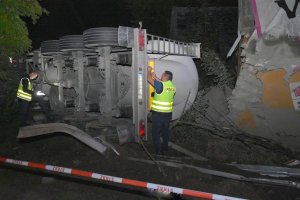 Zdjęcie przedstawia policjantów oraz przewróconą ciężarówkę.