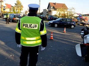 Zdjęcie przedstawia Policjanta na parkingu podczas akcji &quot;Znicz&quot;