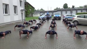 Zdjęcie przedstawia funkcjonariuszy Policji robiących pompki.