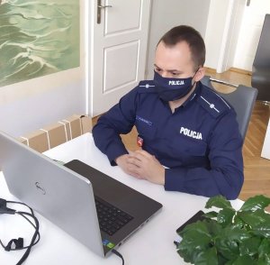 Zdjęcie przedstawia policjanta przed komputerem