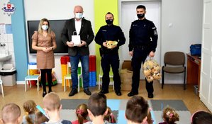 Zdjęcie policjantów, wójta, dzieci i dyrektorki w szkole