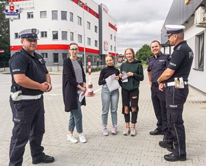 Zdjęcie przedstawia młodych kierowców po egzaminie i policjantów