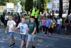 Zdjęcie przedstawia dzieci przechodzące przez ulicę