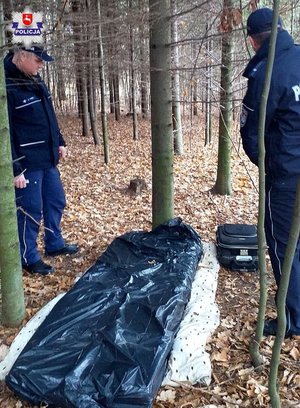 Policjant nad prowizorycznym łóżkiem bezdomnego