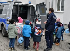 Dzieci z policjantką oglądają radiowóz