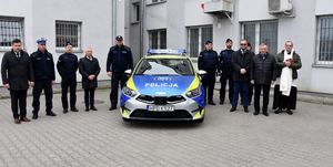 Zdjęcie radiowozu i policjantów oraz samorządowców