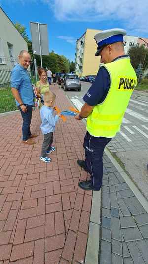 Zdjęcie przedstawia policjanta z uczniami