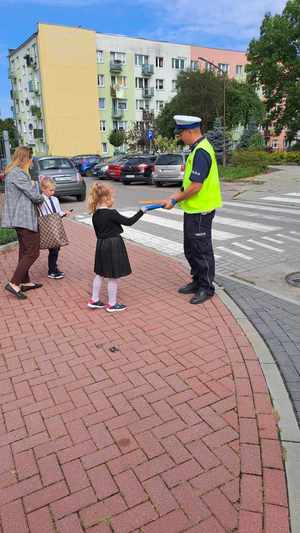 Zdjęcie przedstawia policjanta z uczniami