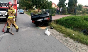 Zdjęcie przedstawia akcję ratowniczą i samochód na dachu