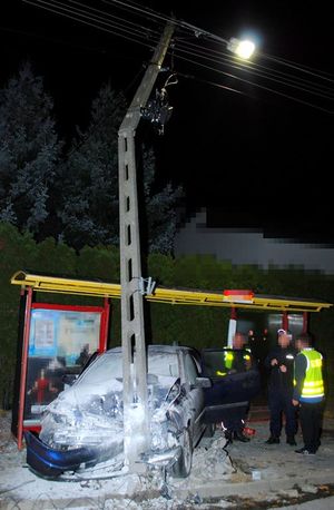 Zdjęcie uszkodzonego pojazdu i przystanku i latarni