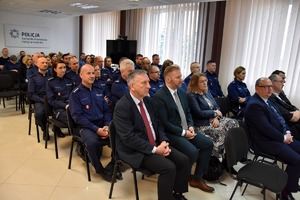 Policjanci i zaproszeni goście słuchają prezentacji