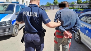 Mężczyzna prowadzony przez Policjanta