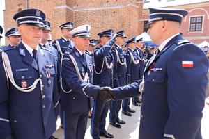 Zdjęcie naczelnika ruchu drogowego pomiędzy policjantami