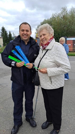 Zdjęcie policjanta i seniorki podczas wręczania odblasków