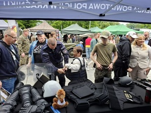 policjanci oraz zainteresowani mieszkańcy przy stoisku
