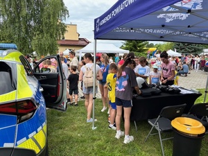 chłopcydmężczyzna w radiowoziezielnicofestyn i stoiskodziewczynka w radiowoziewy przy radiowozie wstoisko na festynie bieg po uśmiechradioprezentacja wyposażeniawozieprezentacja wycinanek przez policjanta