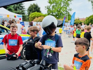 chłopcydmężczyzna w radiowoziezielnicofestyn i stoiskodziewczynka w radiowoziewy przy radiowozie wstoisko na festynie bieg po uśmiechradioprezentacja wyposażeniawozieprezentacja wycinanek przez policjanta