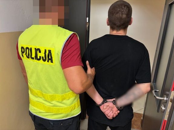 policjant i doprowadzany zatrzymany