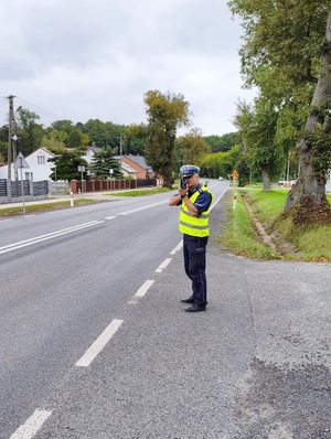 policjant w trakcie dokonywanego pomiaru prędkości