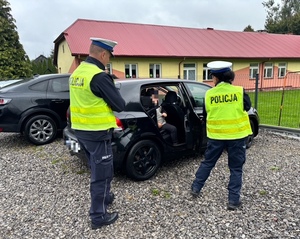 dziecko z ciemnego auta wysiada z fotelika