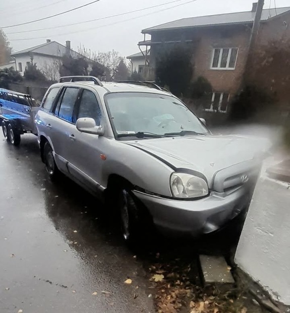 samochód koloru srebrnego z przyczepką wjechał w studnię