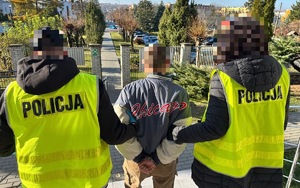 policjanci prowadzający zatrzymanego na posiedzenie do sądu