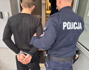 policjant i doprowadzany zatrzymany