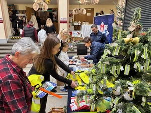 policjanci wraz z uczestnikami przy stoisku światecznym