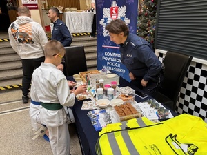 policjantka pomaga dzieciom przy stoisku