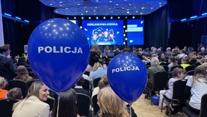 na widowni siedzą ludzie , widać balony z napisem policja