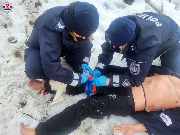 dwie policjantki na manekinie medycznym zakładają stazę
