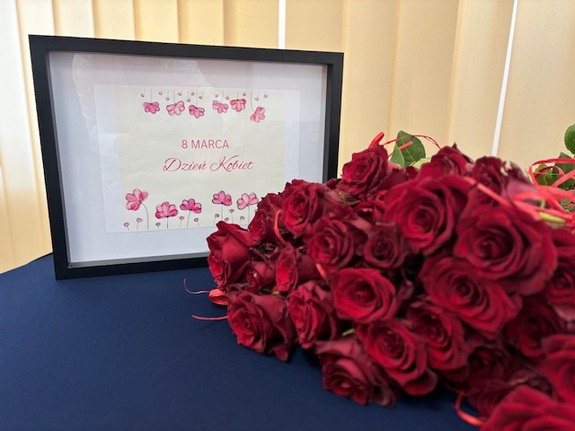 kwiaty i zdjęcie w ramce z napisem 8 marca Dzień Kobiet