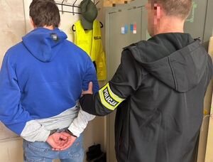 zatrzymany z policjantem stoją tyłem