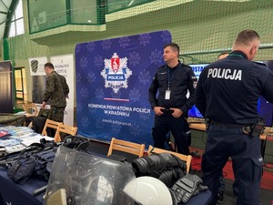 dwaj policjanci stojący przy stoisku na targach edukacyjno zawodowych