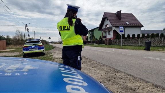 policjantka stoi za radiowozem