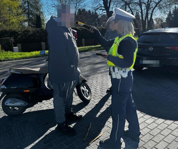 policjantka przeprowadza badanie trzeźwości urządzeniem koloru żółtego