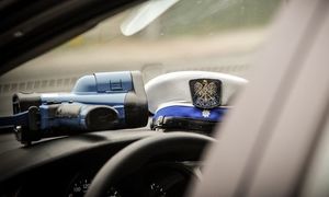 na desce rozdzielczej widać białą czapkę policyjną Wydziału Ruchu Drogowego oraz urządzenie do pomiaru prędkości