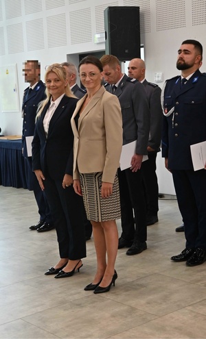 pracownice cywilne stoją przed szykiem policjantów